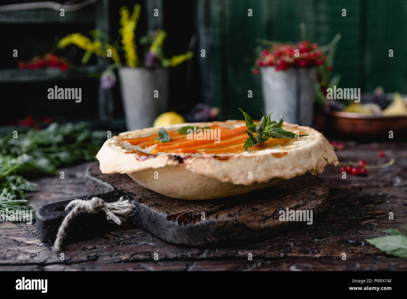 Messa a fuoco selettiva di una gustosa torta con le carote e le erbe sul tavolo di legno Foto Stock