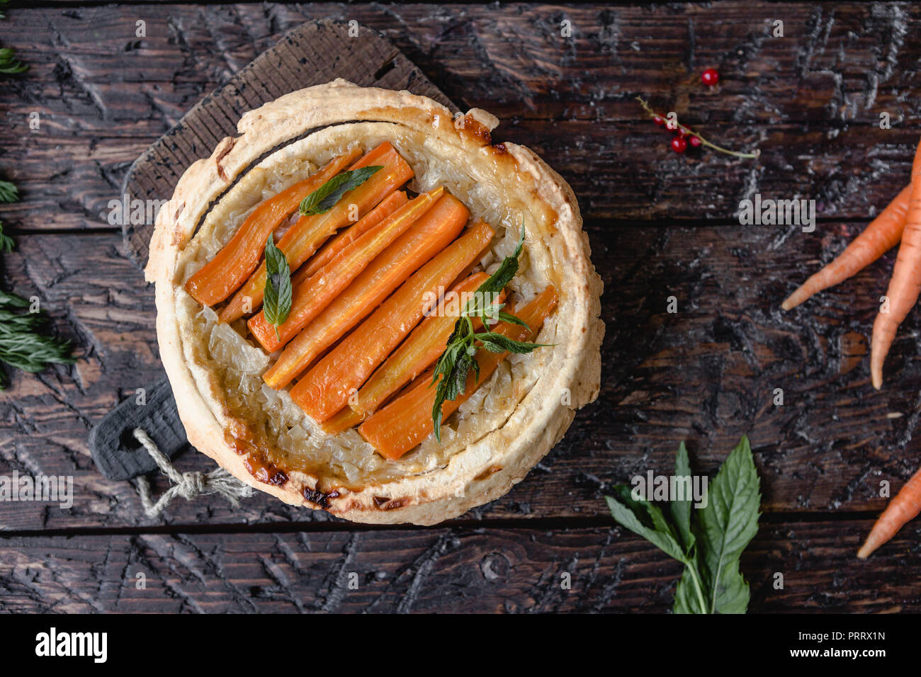 Vista in elevazione di una deliziosa torta di carote e le erbe sul tavolo di legno Foto Stock