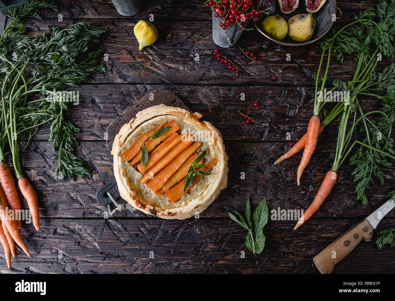 Vista superiore della gustosa torta con le carote e le erbe sul tavolo di legno Foto Stock