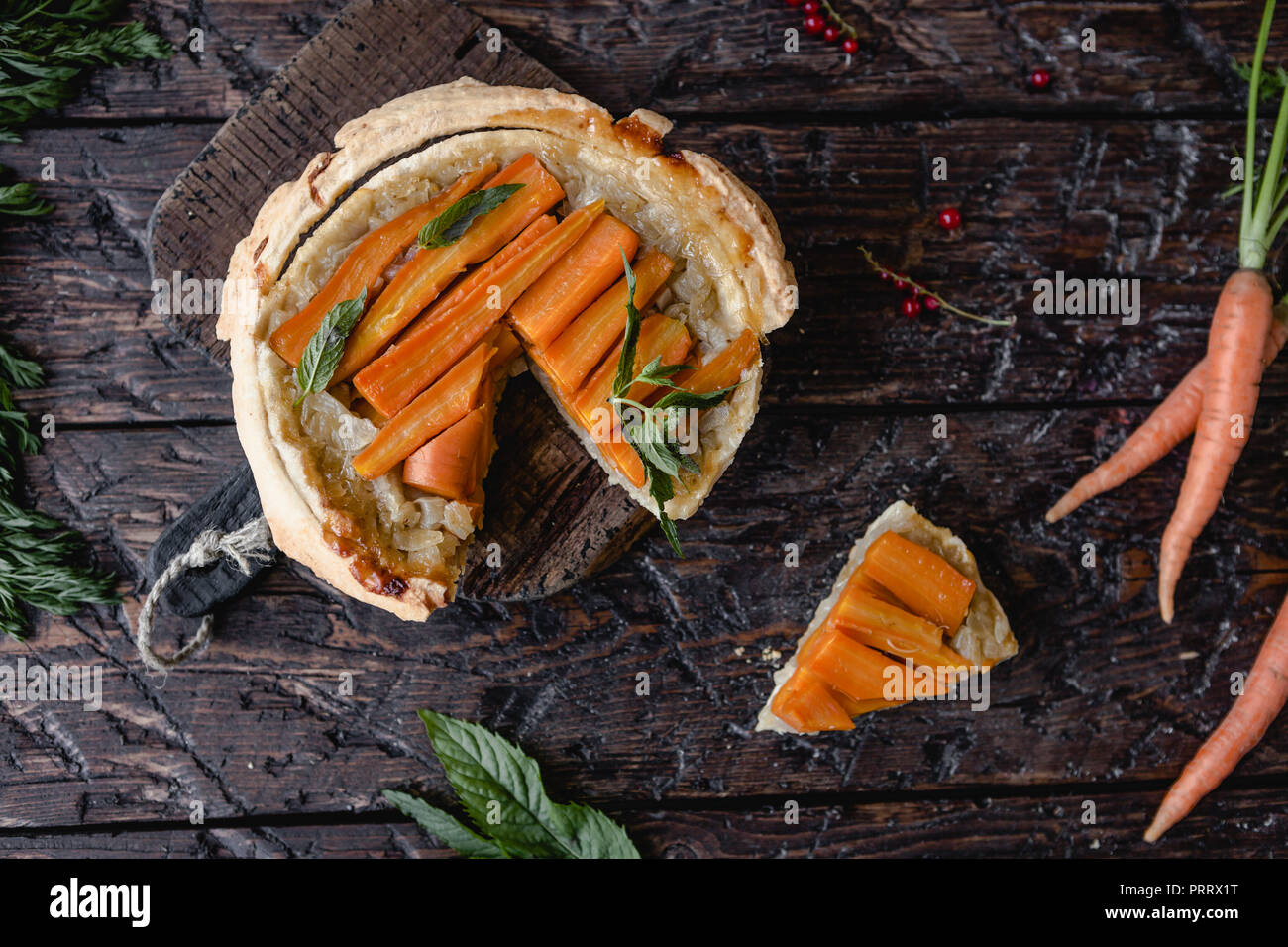 Vista in elevazione di una gustosa torta con le carote e le erbe sul tavolo di legno Foto Stock