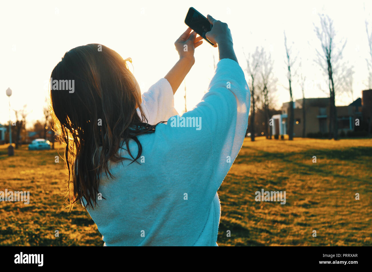 Donna che indossa accappatoio prendendo un selfie foto all'aperto al tramonto Foto Stock