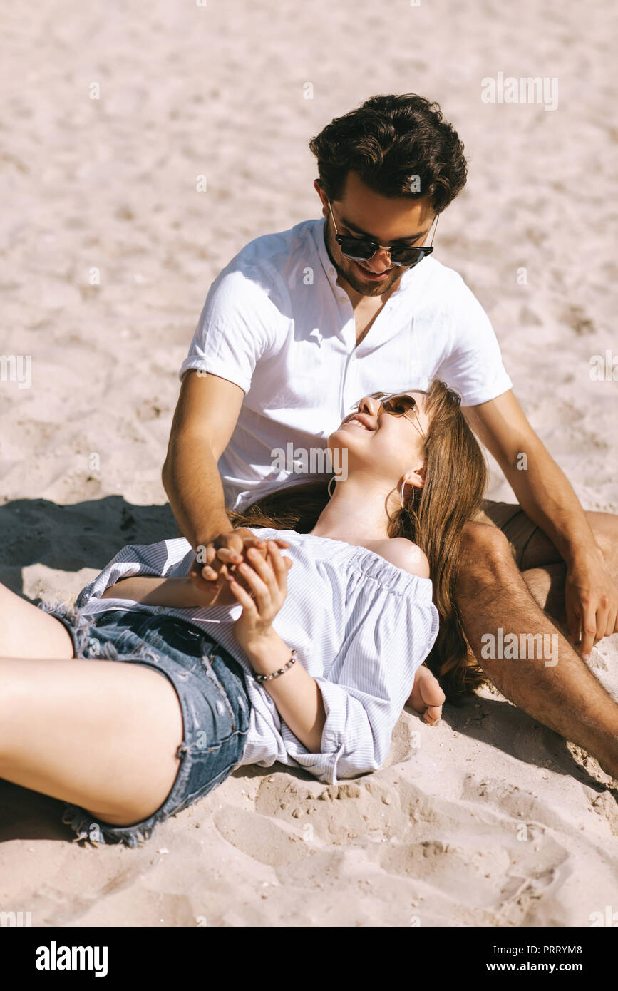 Ragazza giacente su fidanzati gambe sulla spiaggia di sabbia della città  Foto stock - Alamy