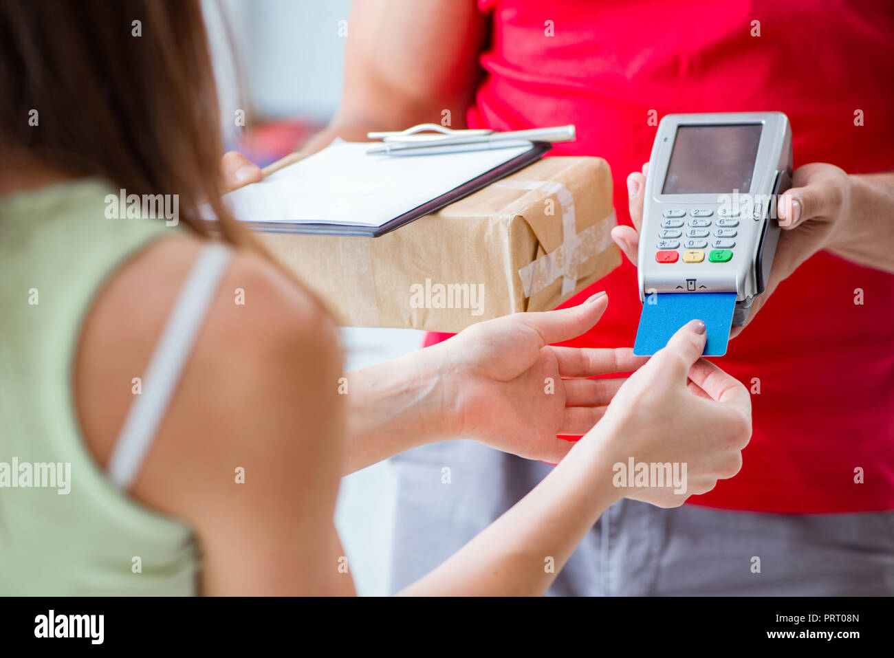 La consegna di pacchi essendo pagato con pos e carta di credito Foto Stock