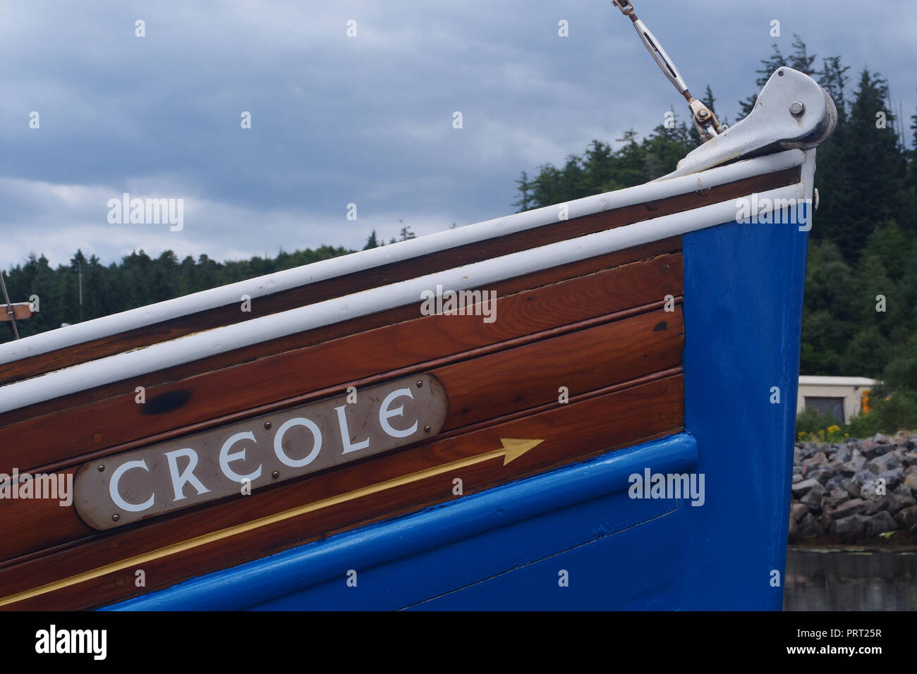 Close up di prua di un rinnovato di recente la barca di legno dipinte di blu profondo che mostra i dettagli dell'archetto e nome Foto Stock