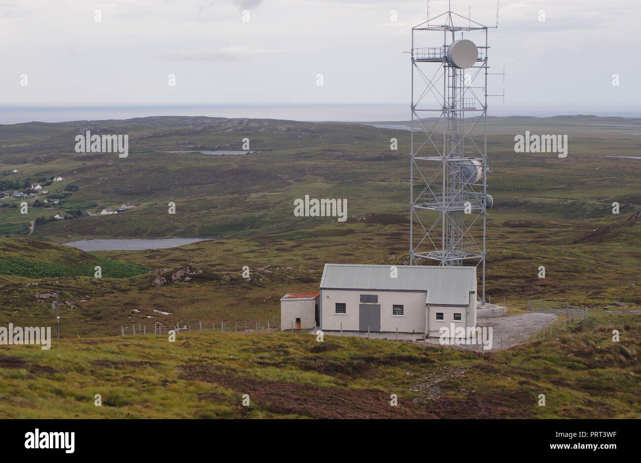 Una vista di una radio/televisione stazione del montante in un paesaggio selvaggio nel nord-ovest della Scozia si affaccia crofts Foto Stock