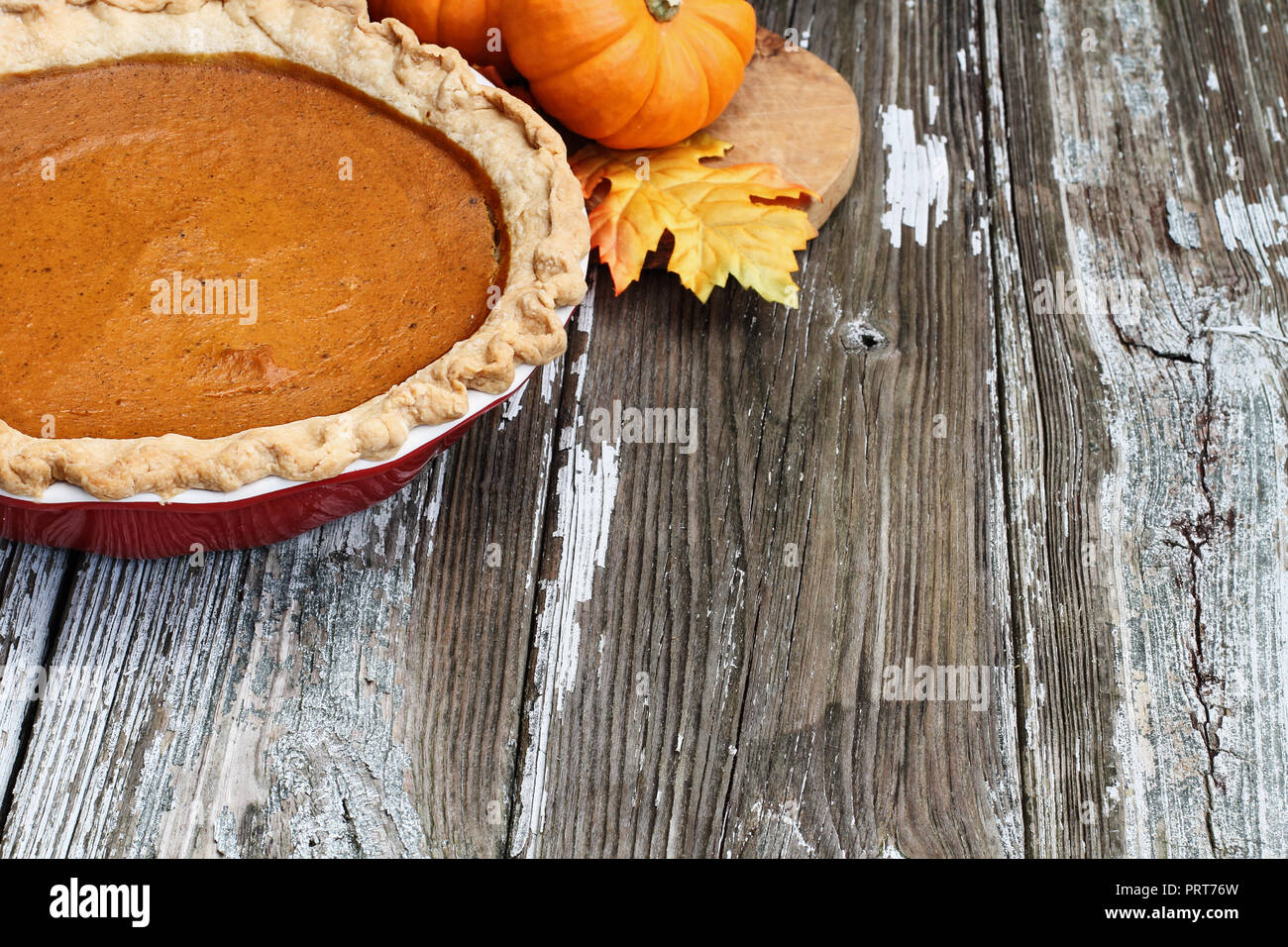 In casa torta di zucca in ceramica rossa piastra a torta su un rustico sfondo di legno. Estrema profondità di campo con il fuoco selettivo. Foto Stock