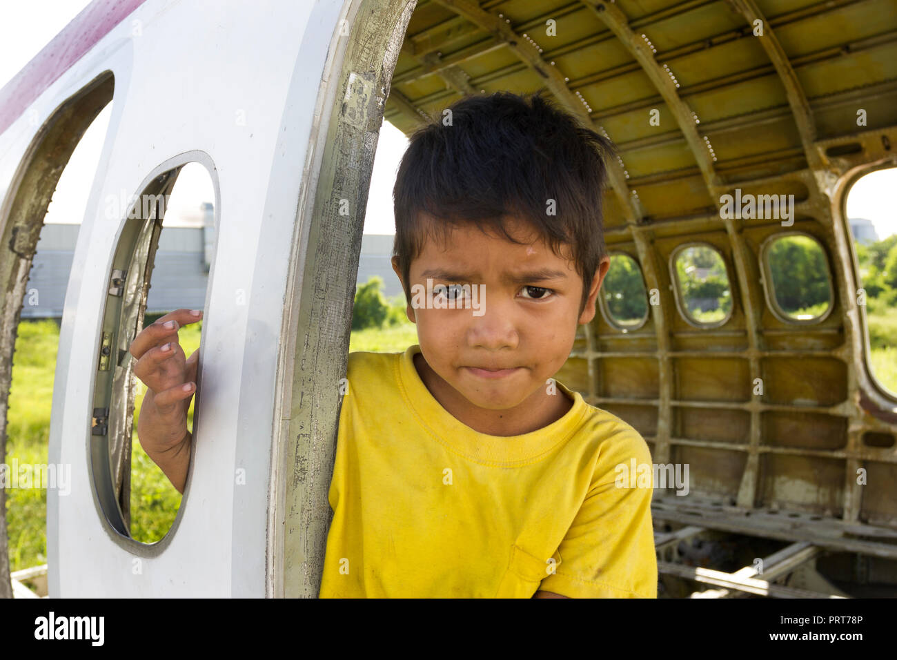 Giovane ragazzo giocando in piano di antichi relitti. Bangkok, Thailandia Foto Stock