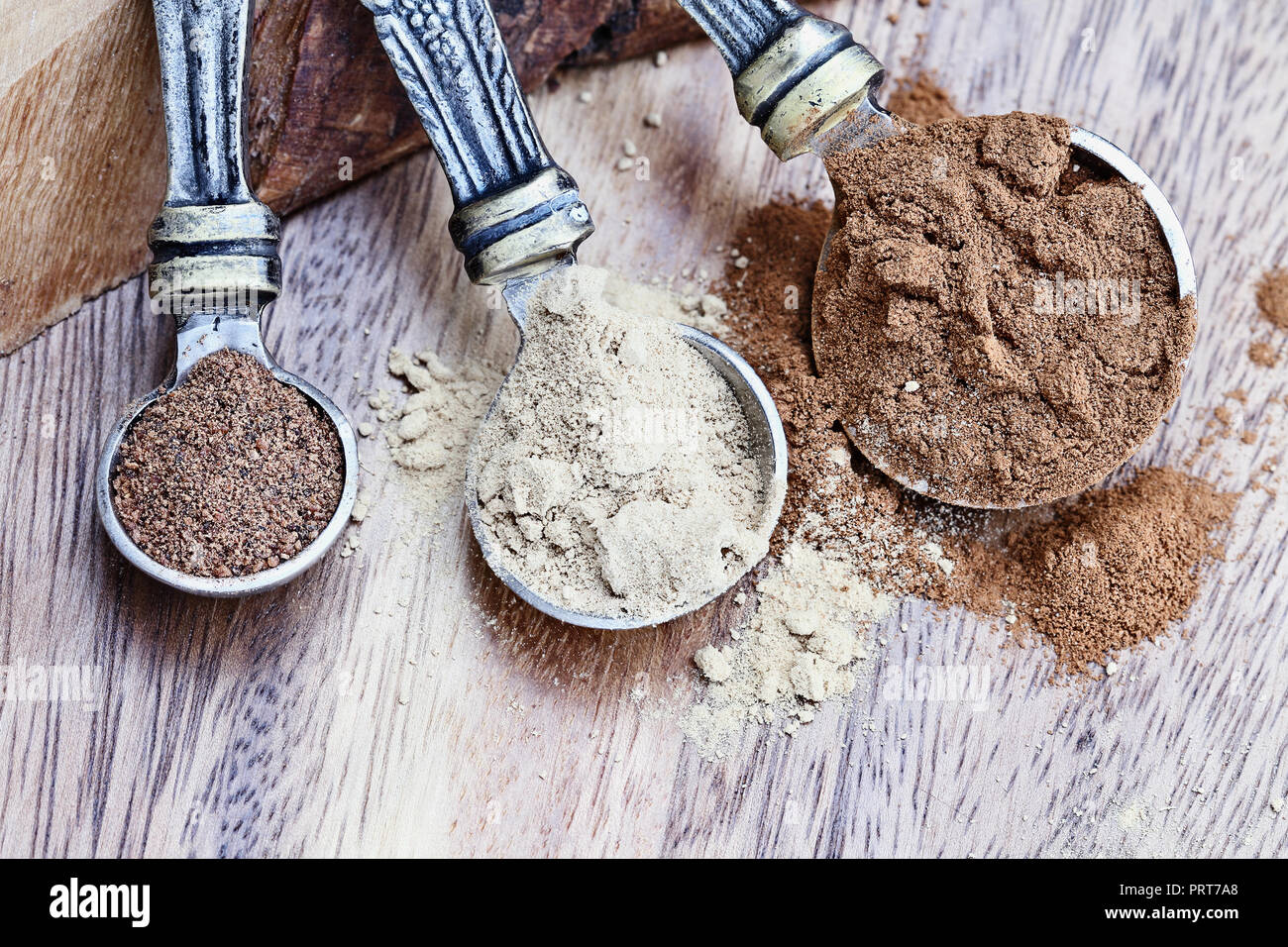 Misurino riempito con la miscela di spezie per la torta di zucca gli ingredienti con la cannella, lo zenzero e la noce moscata oltre un rustico sfondo di legno. Estrema profondità di f Foto Stock