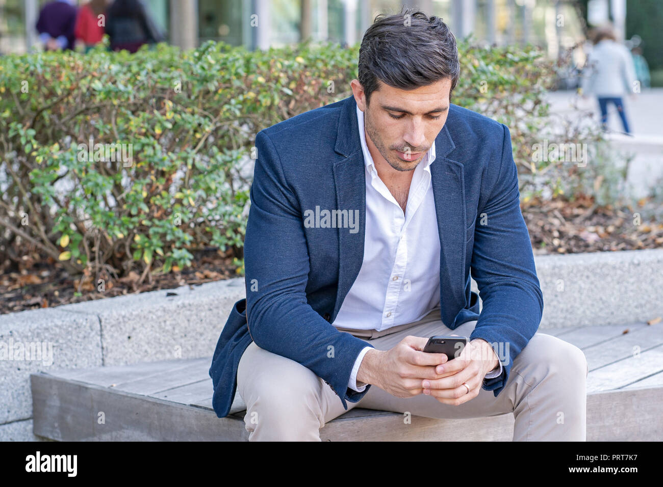 Attraente, imprenditore moderno a parlare e scrivere sul suo telefono cellulare. Imprenditore di successo facendo il lavoro. Foto Stock