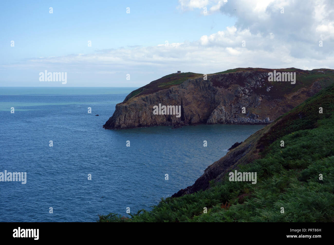 Il rovinato Summerhouse (Lookout) sulla testa Llanlleiana attraverso la baia e sull'Isola di Anglesey sentiero costiero, Wales, Regno Unito. Foto Stock