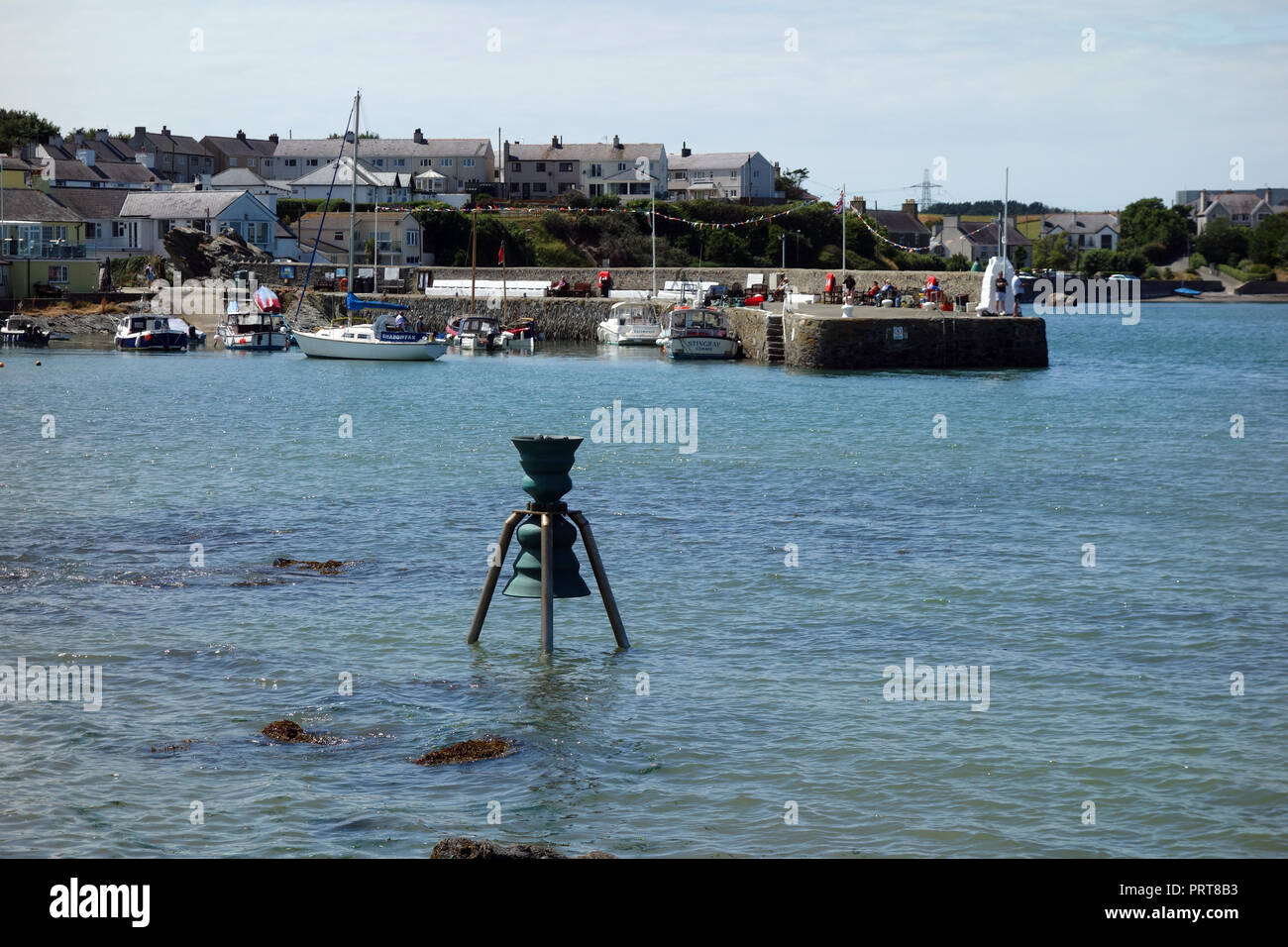 St Patrick Bell Tempo & Tide nel porto nel villaggio di Cemaes sull'Isola di Anglesey sentiero costiero, Wales, Regno Unito. Foto Stock