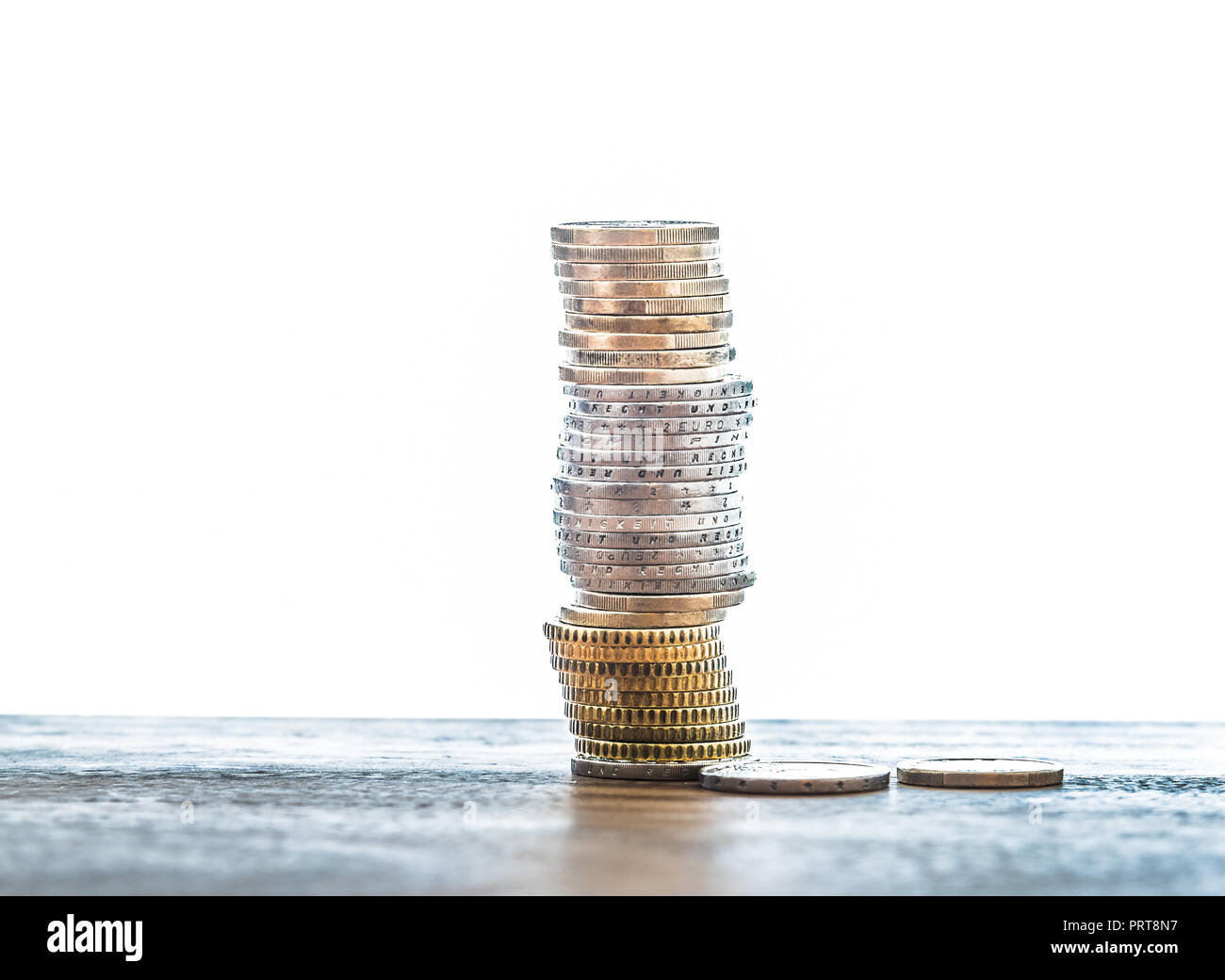Pila di monete in euro sul tavolo contro uno sfondo bianco Foto Stock
