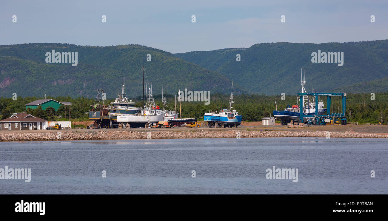 CHETICAMP, Nova Scotia, Canada - barche da pesca in drydock sulla spiaggia, Cape Breton Island. Foto Stock