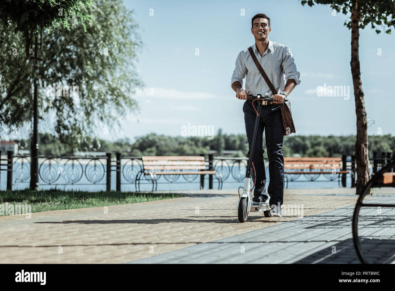Piuttosto entusiastico ragazzo di abituarsi a scooter elettrico Foto Stock
