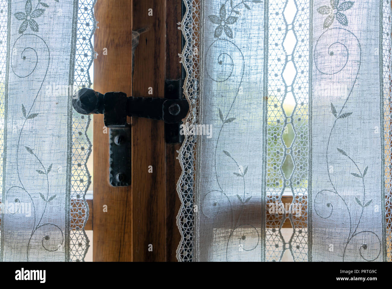 La finestra dietro una cortina ricamata Foto Stock