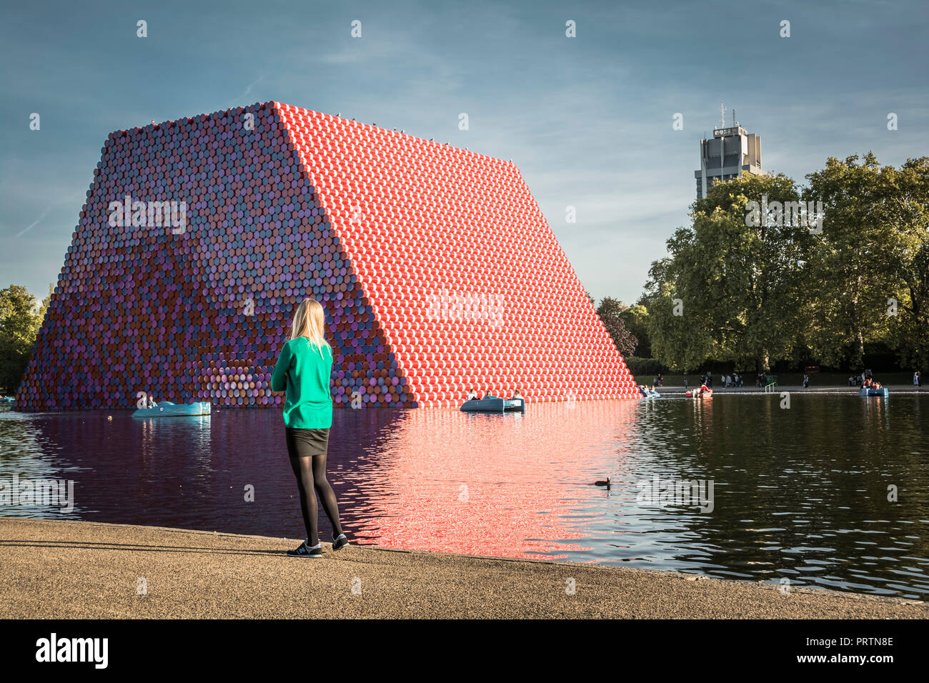 Una giovane donna si erge di fronte a Christo e Jeanne-Claude è il London Mastaba, su Londra la serpentina, London, Regno Unito Foto Stock