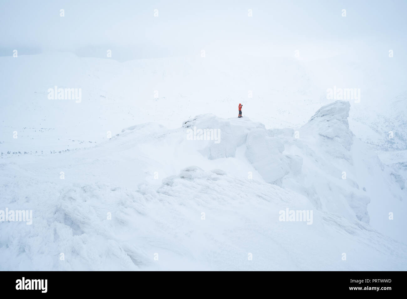 Montagne innevate in inverno. Tourist fotografo scatta foto con la neve. Paesaggio nella nebbia meteo Foto Stock