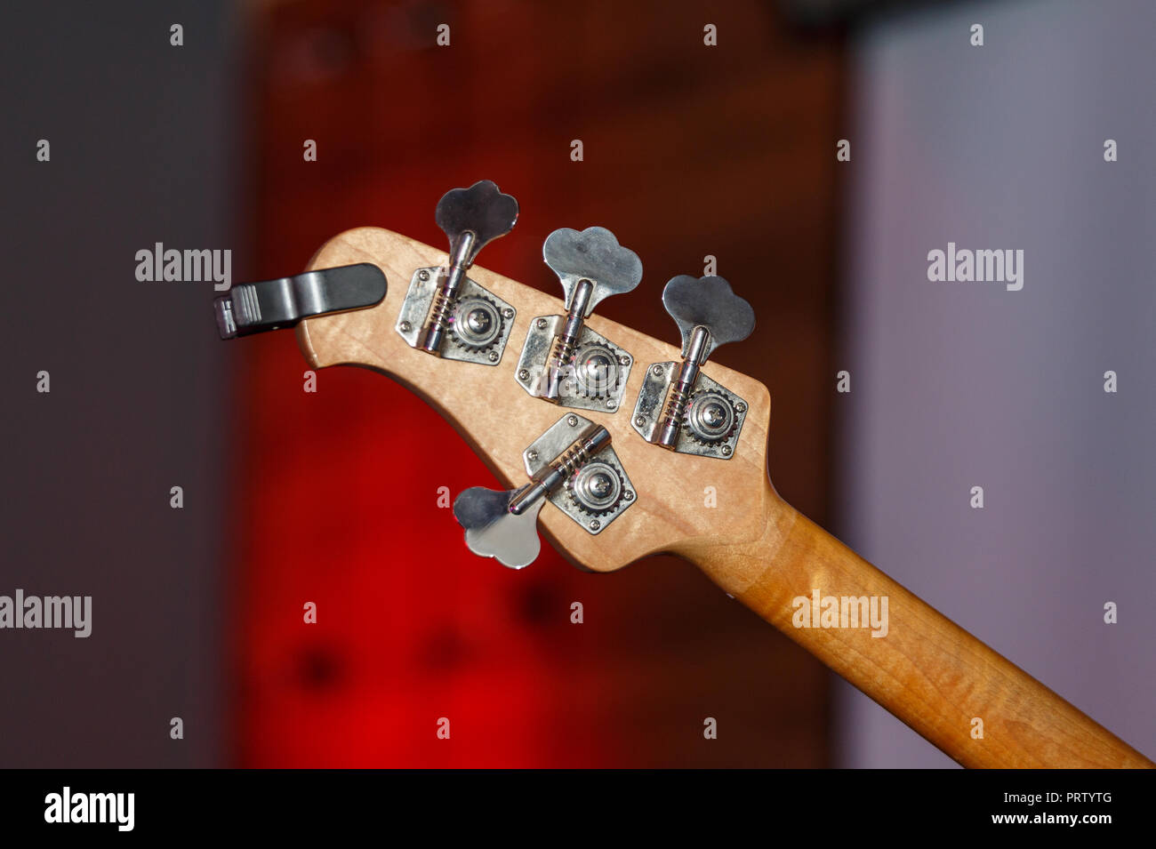 Chitarra basso su una parete rossa sullo sfondo Foto Stock