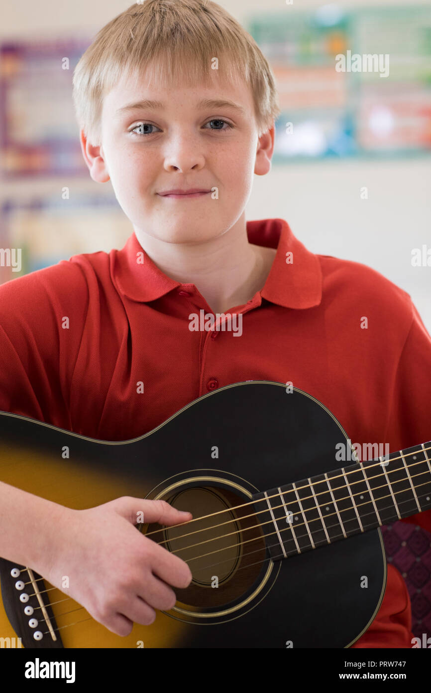 Ritratto maschile di alta scuola allievo a suonare la chitarra Foto Stock