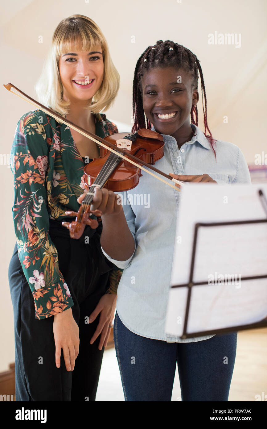 Ritratto di donna Insegnante di scuola superiore con studente suona il violino nella lezione di musica Foto Stock