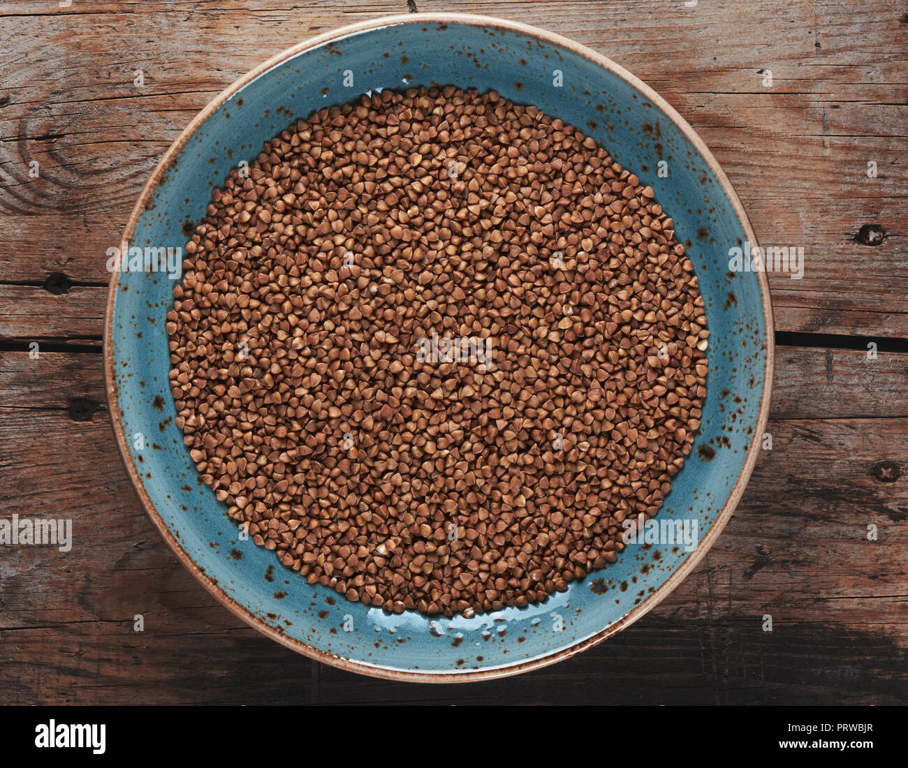 Grano saraceno chicchi di cereali sullo sfondo di legno. Foto Stock