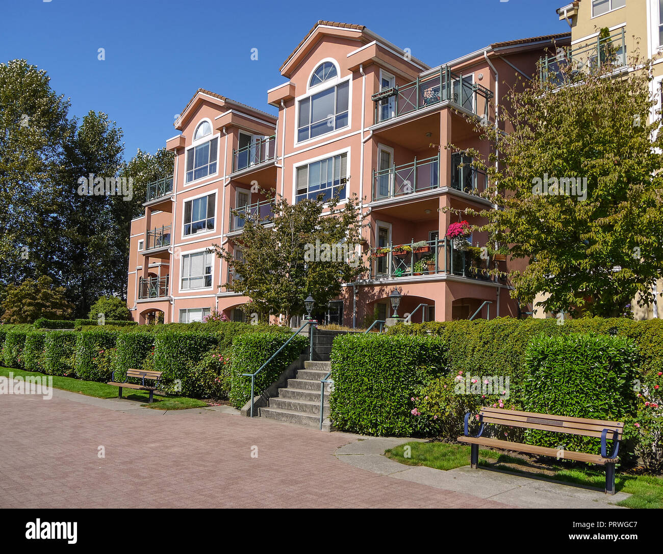 Appartamento Edificio sulla giornata soleggiata con panca e viale lastricato in parte anteriore Foto Stock