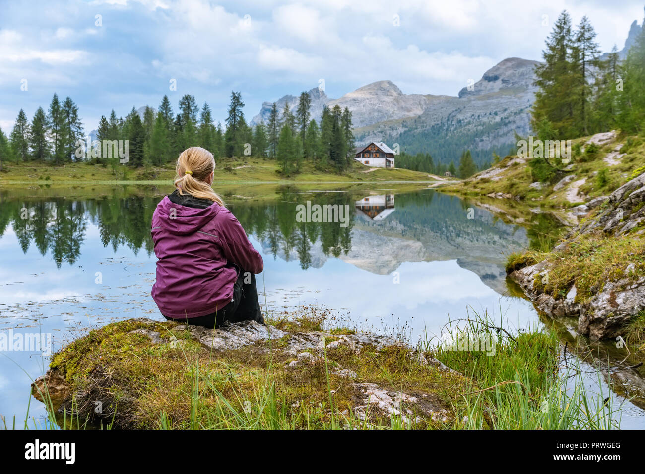 Donna rilassante vicino al bellissimo lago di Federa in Dolomiti Italia Foto Stock