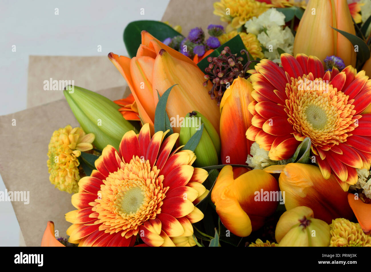 Un mazzo di fiori di close-up. Rosso, giallo, arancio e fiori lilla sono raccolti in un mazzo di fiori. Foto Stock