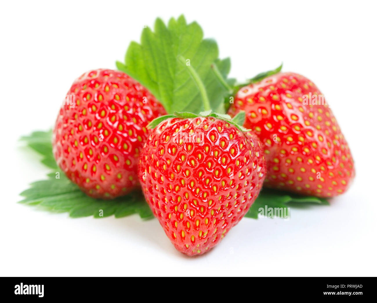Cumulo di fragole mature con foglie verdi isolati su sfondo bianco Foto Stock