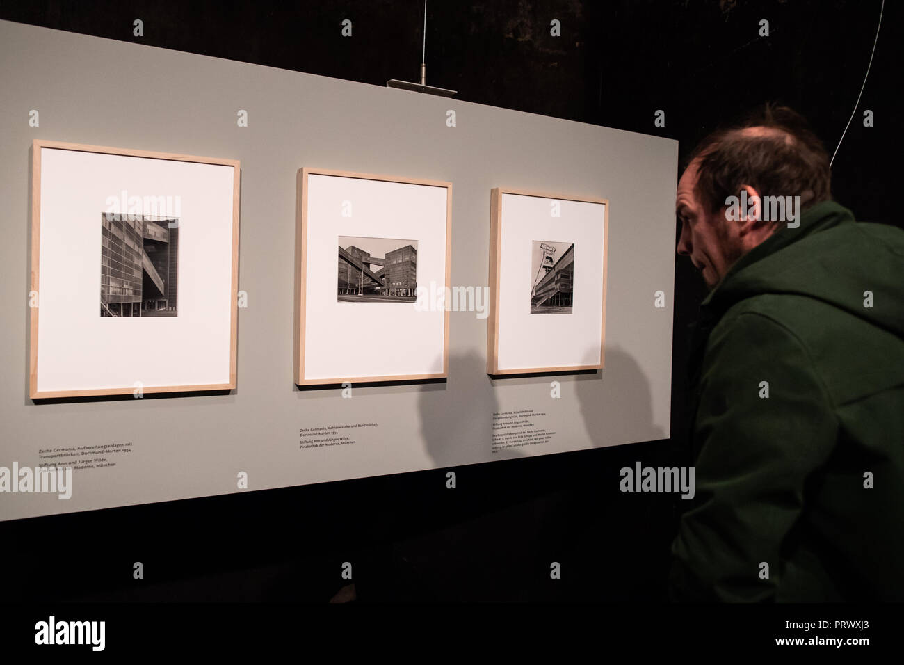 04 ottobre 2018, della Renania settentrionale-Vestfalia, Essen: diverse fotografie di Albert Renger-Patzsch dalla serie 'Zechen II' appendere su una parete rossa nella Ruhr Museum al Zeche Zollverein come parte della mostra 'Die Ruhrgebietsfotografien'. Renger-Patzsch (1897-1966), insieme con August Sander, è uno dei più importanti fotografi documentario della Repubblica di Weimar. La sua zona della Ruhr le fotografie sono state prese tra il 1927 e il 1935 e impostare lo stile per fotografia industriale. Foto: Marcel Kusch/dpa Foto Stock