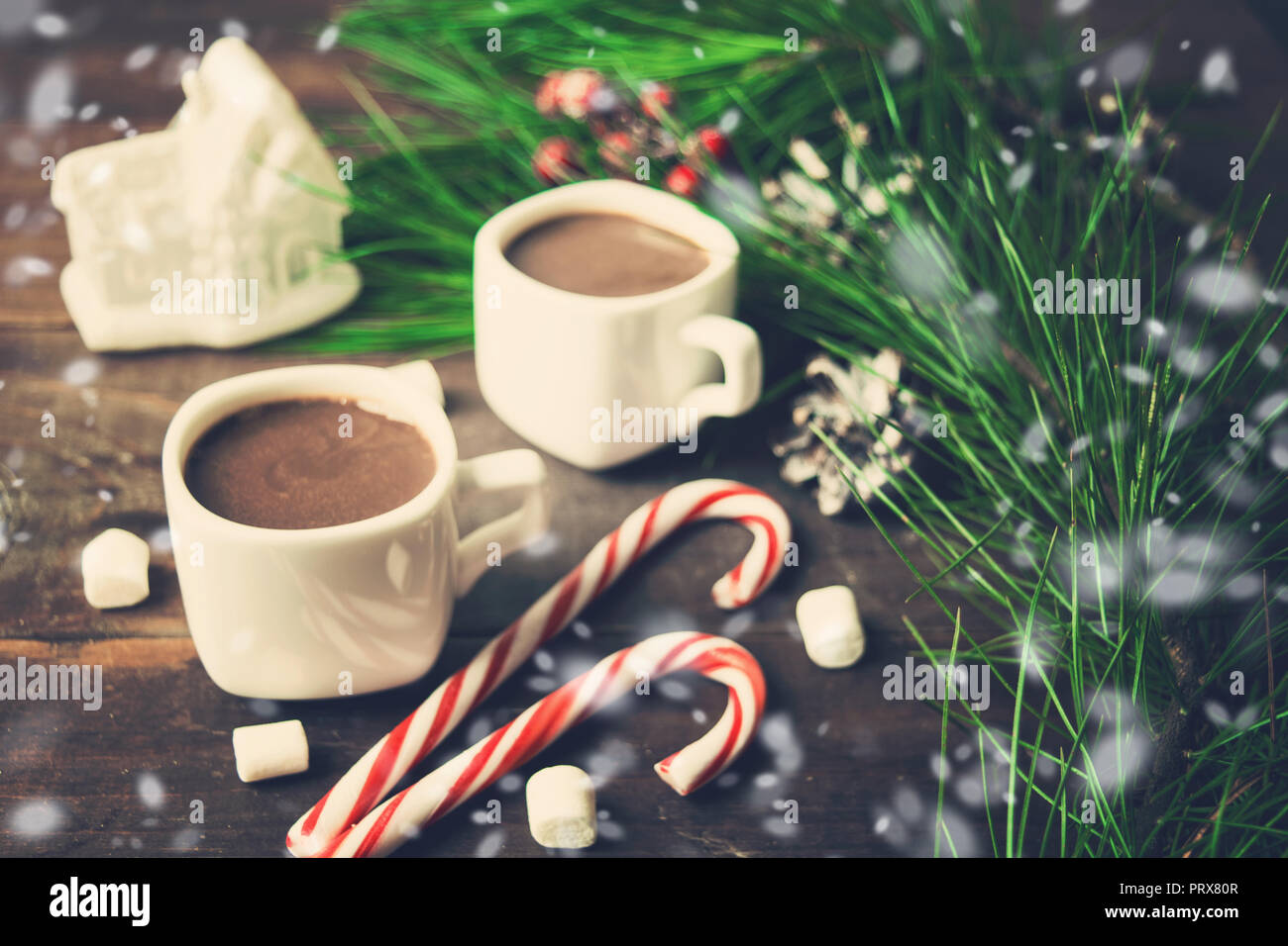 Anno nuovo o di Natale ancora in vita con due tazze di cioccolata calda e decorazioni su sfondo di legno con la neve, tonica foto Foto Stock