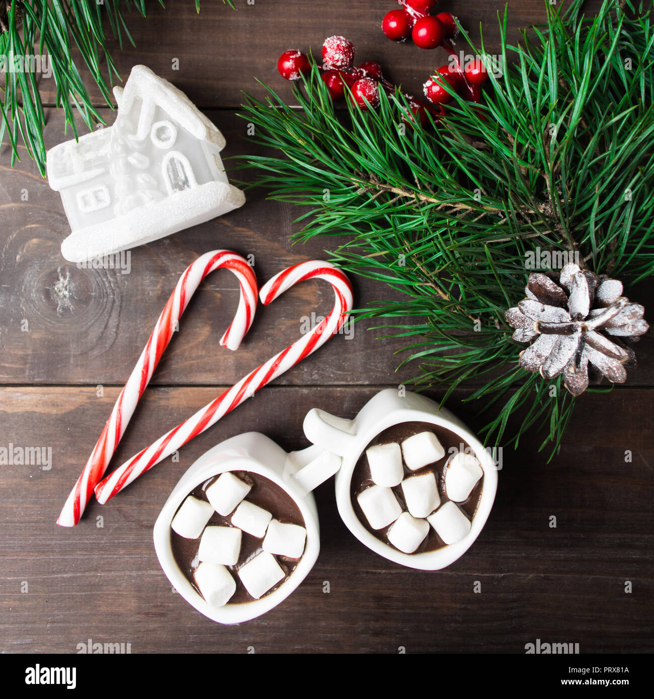 La cioccolata calda con marshmallow con casa di giocattoli e caramelle con albero di natale su sfondo di legno Foto Stock