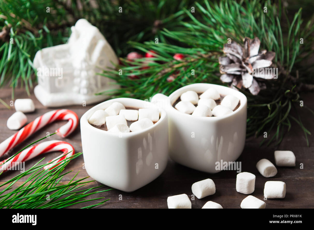 Due tazze di cioccolata calda con marshmallow con decorazioni di Natale sulla tavola di legno, fuoco selettivo Foto Stock