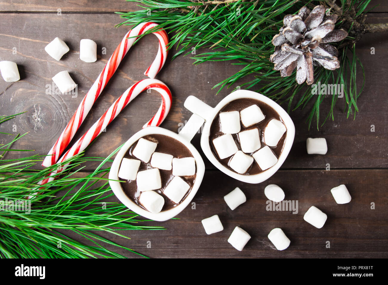 Piatto di laici bevanda calda con marshmallow con lecca lecca e abete marrone su un tavolo di legno Foto Stock
