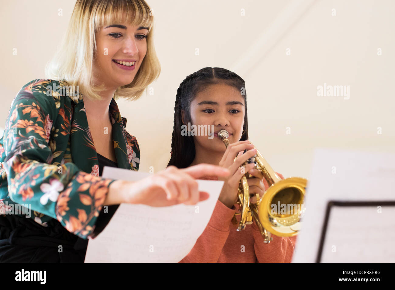 Insegnante aiutando Studentessa per suonare la tromba nella lezione di musica Foto Stock