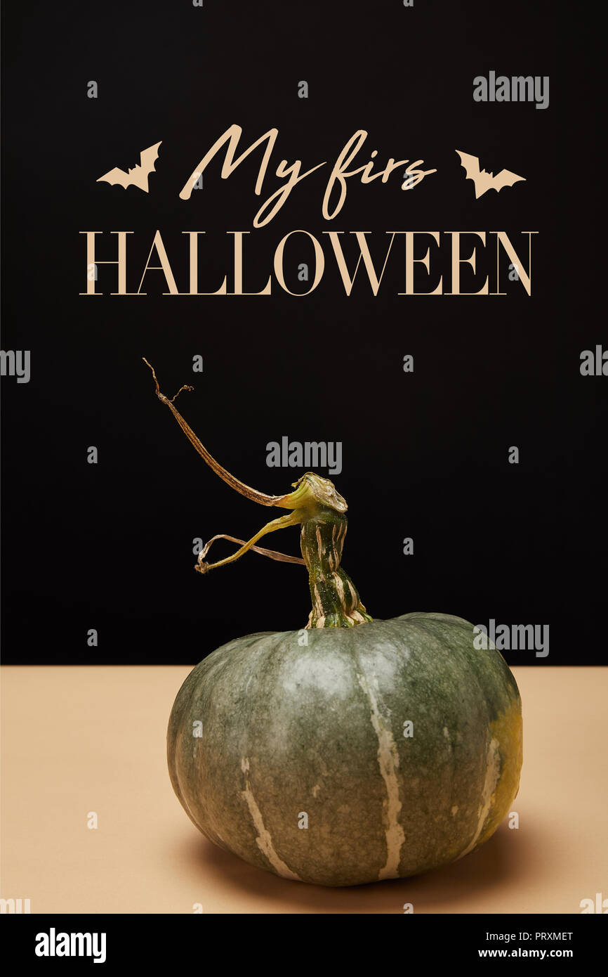 Una zucca verde sulla tabella con i pipistrelli e 'my prima di halloween lettering" Foto Stock