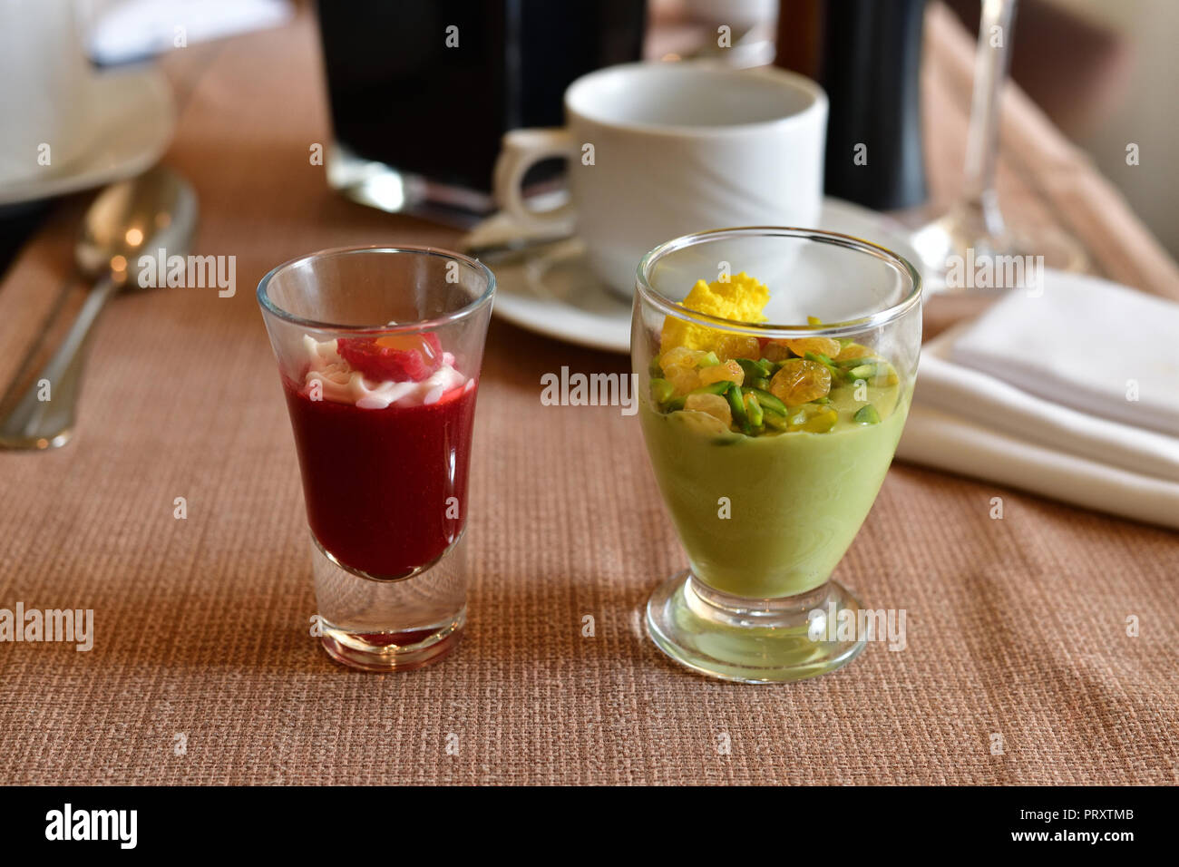 Lampone e pistacchio souffle con uvetta nella porzione bicchieri Foto Stock