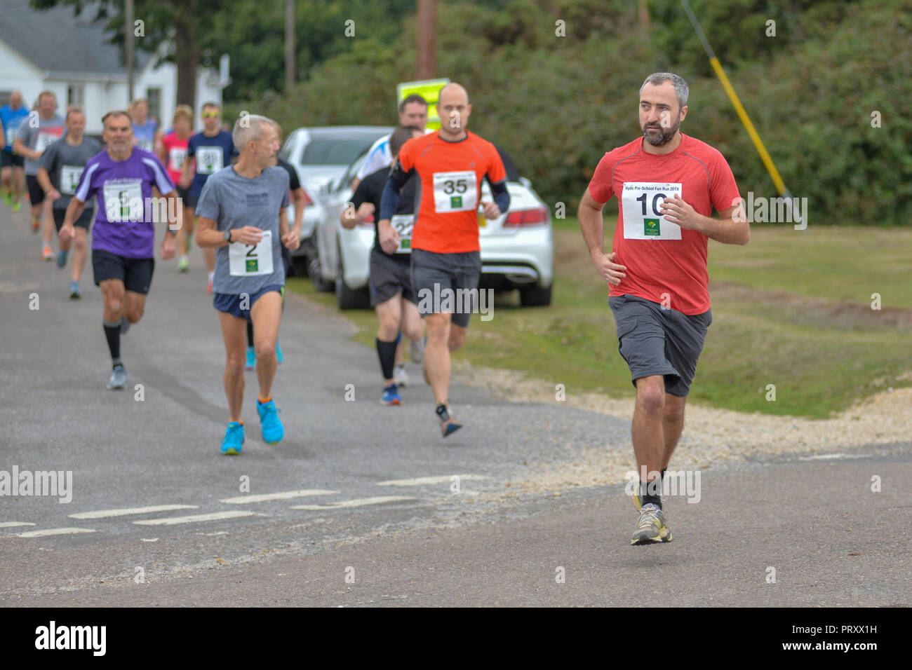 Guide di scorrimento in un dilettante su strada e cross country gara di corsa, New Forest, Hampshire, Regno Unito Foto Stock