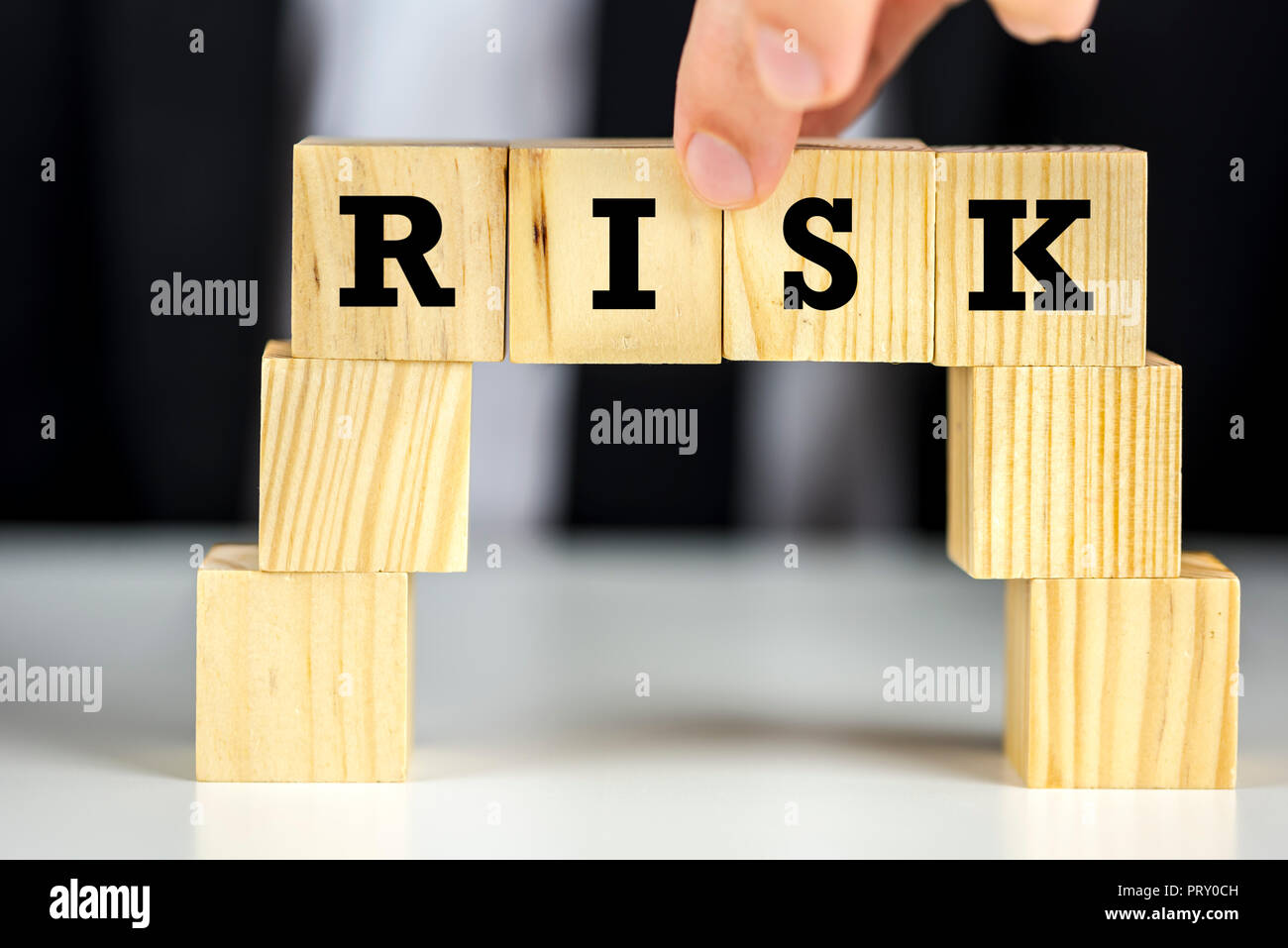 La costruzione di un ponte di cubi di legno con rischio di parola scritta su di essi. Foto Stock