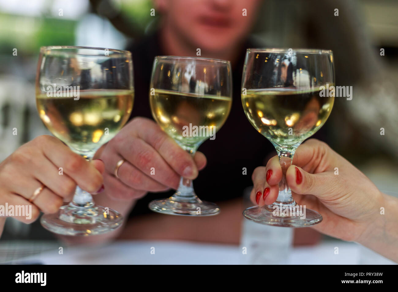 Versare il vino bianco in vetro contro il tavolo di legno. Cena romantica. Foto Stock