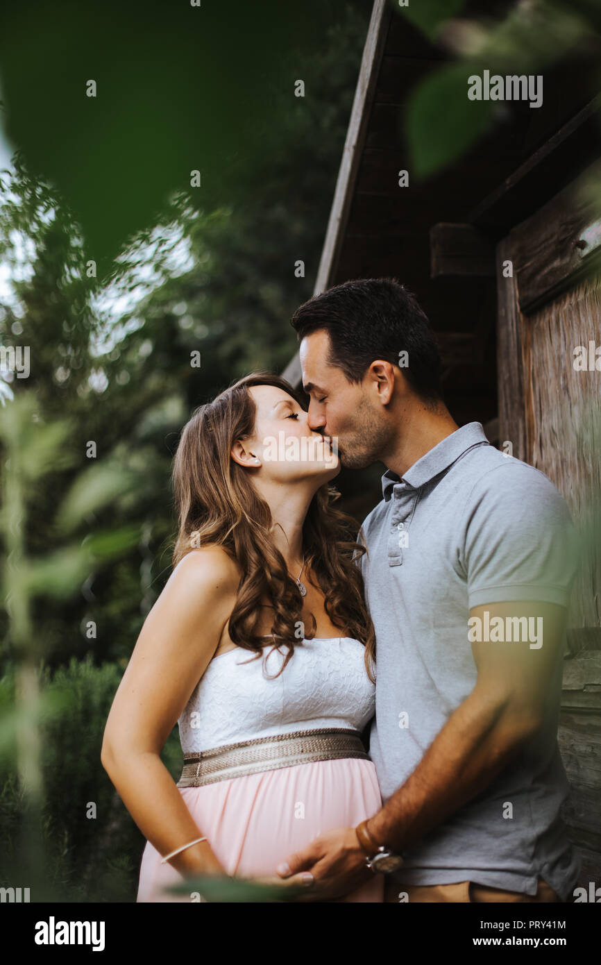 Il marito è baciare sua moglie incinta Foto Stock
