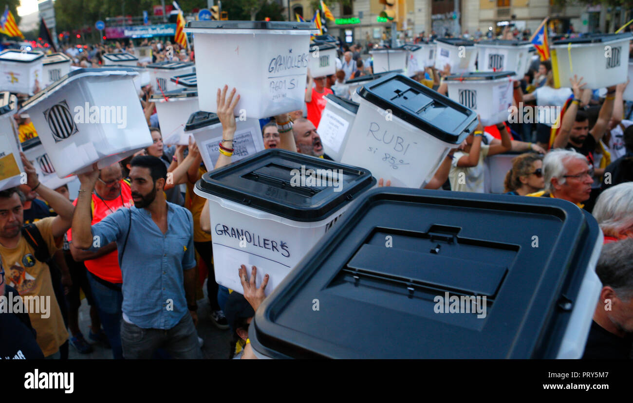 Persone alzare le mani e gridare slogan mentre trasportano i turni di votazione utilizzata lo scorso anno bandita independendence referendum in Catalogna Foto Stock