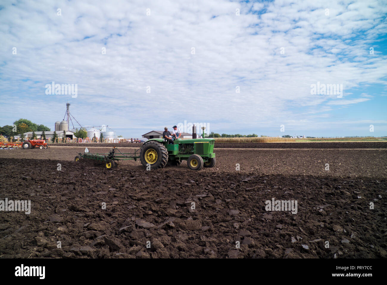 1966 Trattore John Deere tirando un 7-Fondo aratro in un antico trattore dimostrazione a fattoria di famiglia vicino a Hebron, Illinois. Foto Stock