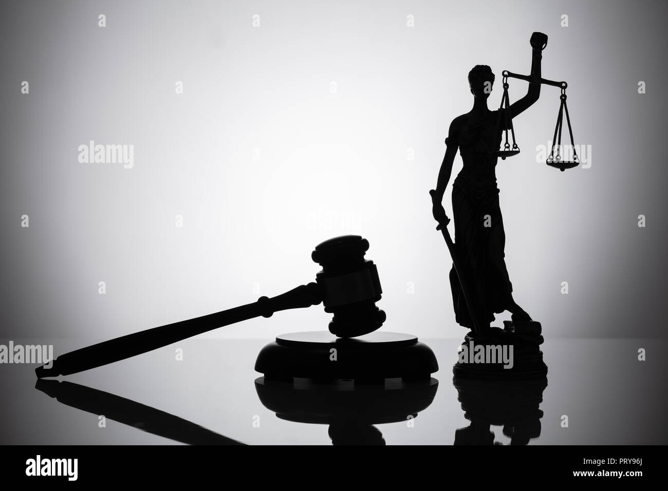 Statua di giustizia e martello su sfondo riflettente Foto Stock