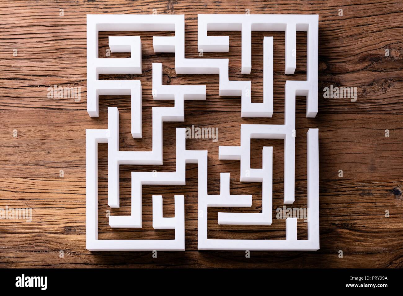 Vista aerea di astratta labirinto bianco su sfondo di legno Foto Stock