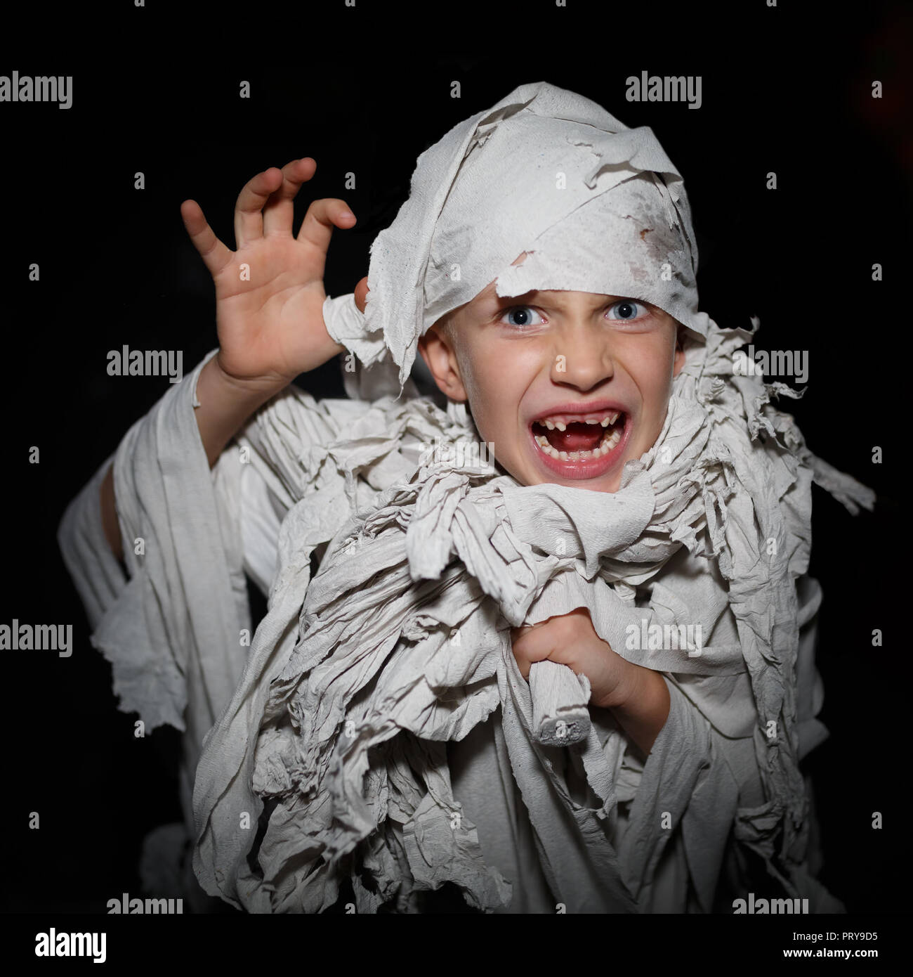 Bambino avvolto in fasce bianche come una mummia egiziana, fare si affaccia  su uno sfondo nero Foto stock - Alamy