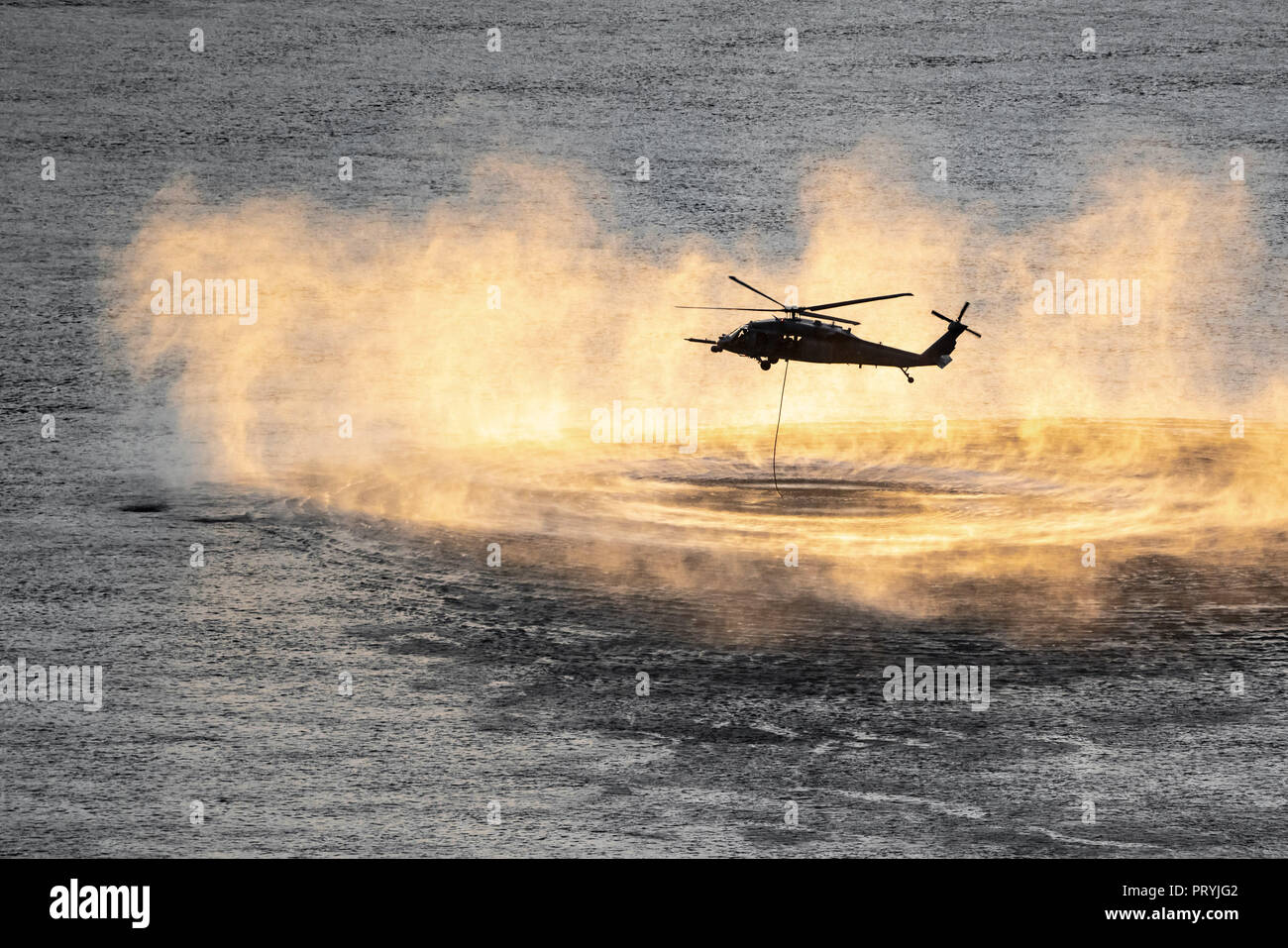 Fino vicino colpo di elicottero di formazione eseguire l'operazione di soccorso oltre il fiume Columbia al tramonto. Foto Stock