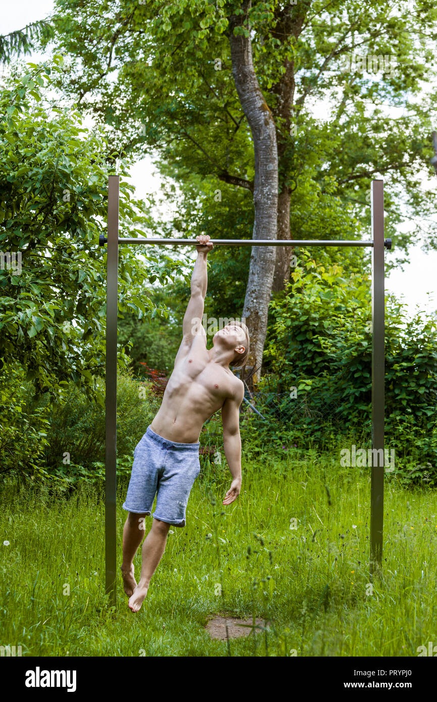 Atletica Giovane uomo sulla barra alta Foto Stock