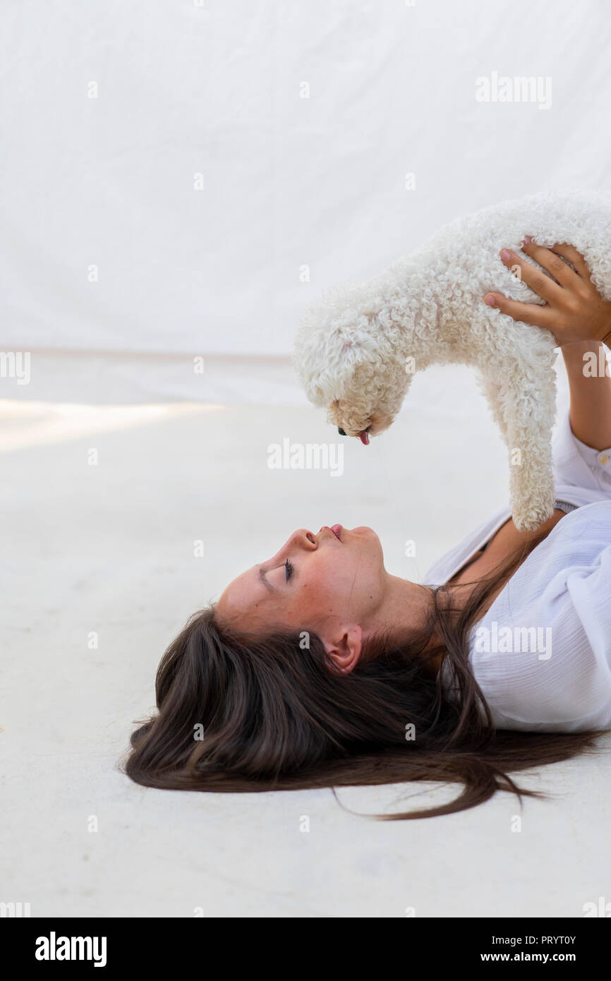 Giovane donna divertendosi con cane sulla terrazza sul tetto Foto Stock