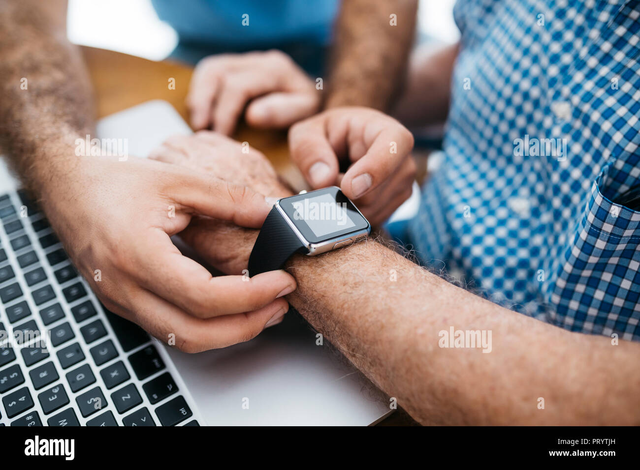 Nipote di adulti insegnamento il nonno di utilizzare smartwatch, close-up Foto Stock